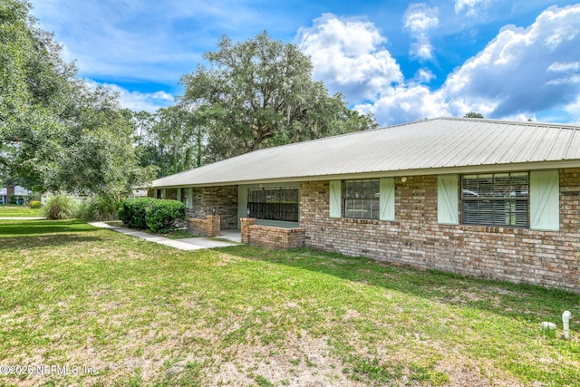 122 Raintree Woods Trl, Palatka, FL 32177 - view of front of property with a front lawn, metal roof, and brick siding