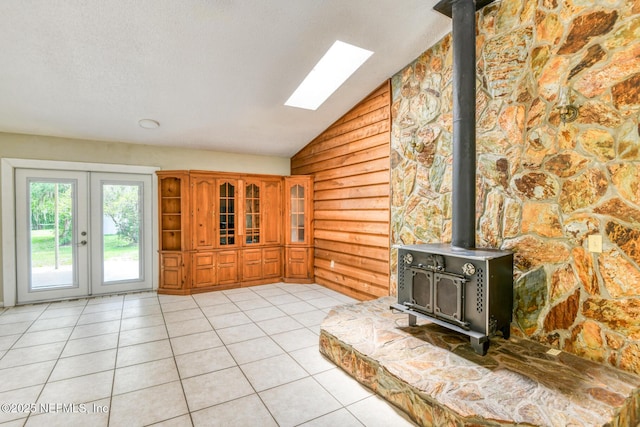 122 Raintree Woods Trl, Palatka, FL 32177 - unfurnished living room with a wood stove, lofted ceiling, a skylight, wooden walls, and french doors