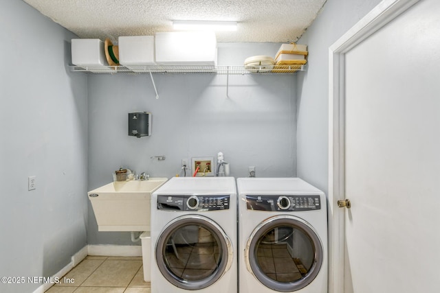 122 Raintree Woods Trl, Palatka, FL 32177 - laundry area featuring washing machine and clothes dryer, light tile patterned floors, a textured ceiling, and baseboards