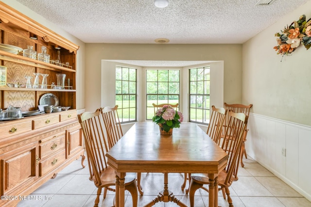 122 Raintree Woods Trl, Palatka, FL 32177 - dining room with light tile patterned floors, wainscoting, and a textured ceiling