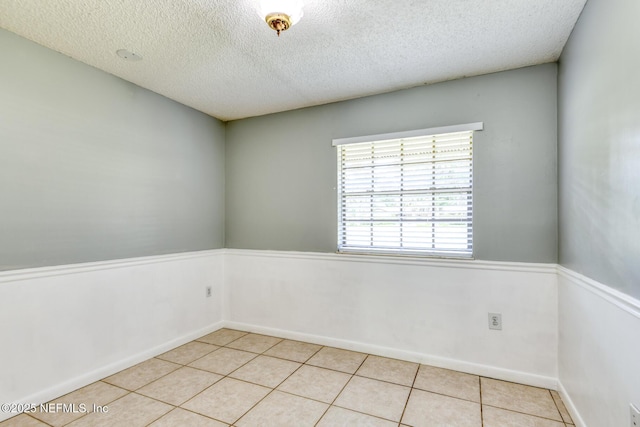 122 Raintree Woods Trl, Palatka, FL 32177 - empty room featuring light tile patterned floors, a textured ceiling, and baseboards
