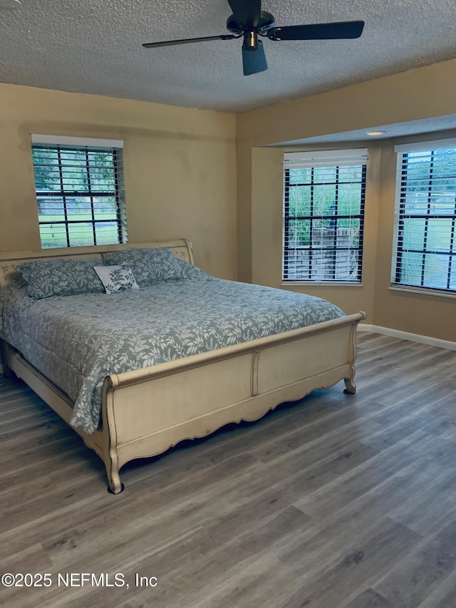 122 Raintree Woods Trl, Palatka, FL 32177 - bedroom featuring wood finished floors, a textured ceiling, a ceiling fan, and baseboards