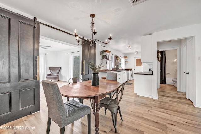 822 Valnera Ct, Saint Augustine, FL 32086 - dining area with a chandelier, light wood-type flooring, and a barn door