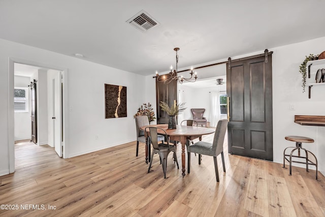 822 Valnera Ct, Saint Augustine, FL 32086 - dining area with plenty of natural light, a barn door, light wood finished floors, and a chandelier