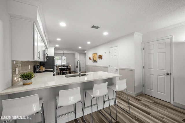 5811 Atlantic Blvd Unit 153, Jacksonville, FL 32207 - kitchen featuring a sink, a peninsula, recessed lighting, light wood finished floors, and white cabinetry