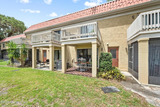 5811 Atlantic Blvd Unit 153, Jacksonville, FL 32207 - rear view of property featuring a balcony, a tiled roof, a patio, and stucco siding