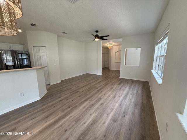 1735 Forest Lake Cir W Unit 2, Jacksonville, FL 32225 - unfurnished living room with wood finished floors, ceiling fan, baseboards, a textured ceiling, and a chandelier