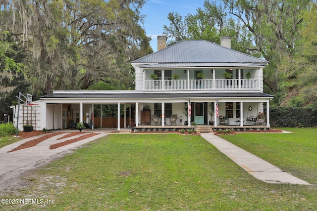 7265 Beach Rd, Elkton, FL 32033 - view of front of house with a chimney, covered porch, driveway, a front yard, and metal roof