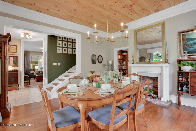 7265 Beach Rd, Elkton, FL 32033 - dining area with wood ceiling, wood finished floors, crown molding, stairs, and a fireplace with raised hearth