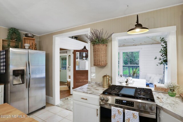 7265 Beach Rd, Elkton, FL 32033 - kitchen with appliances with stainless steel finishes, white cabinets, light tile patterned floors, light stone countertops, and pendant lighting