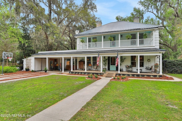 7265 Beach Rd, Elkton, FL 32033 - view of front of property featuring a porch, a chimney, a balcony, metal roof, and a front lawn