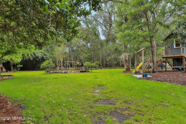 7265 Beach Rd, Elkton, FL 32033 - view of green lawn featuring a playground and view of wooded area