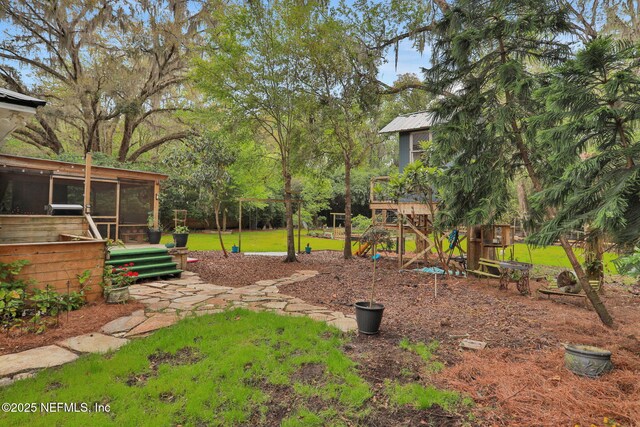7265 Beach Rd, Elkton, FL 32033 - view of green lawn featuring a sunroom and a playground