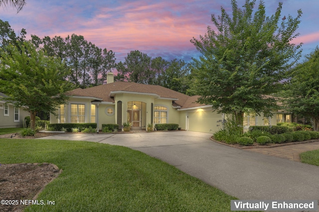 2305 Range Crescent Ct, Fleming Island, FL 32003 - mediterranean / spanish house with concrete driveway, a garage, a chimney, a lawn, and stucco siding