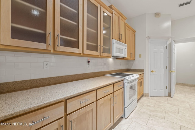 2305 Range Crescent Ct, Fleming Island, FL 32003 - kitchen with white appliances, tasteful backsplash, light brown cabinetry, glass insert cabinets, and light stone countertops