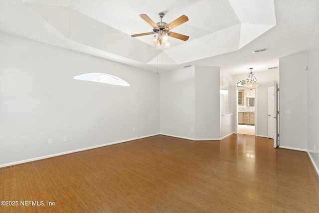 2305 Range Crescent Ct, Fleming Island, FL 32003 - empty room featuring a raised ceiling, wood finished floors, a ceiling fan, baseboards, and a textured ceiling