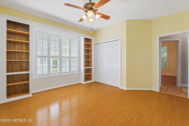 2305 Range Crescent Ct, Fleming Island, FL 32003 - unfurnished bedroom with multiple windows, wood finished floors, a closet, and baseboards