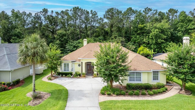 2305 Range Crescent Ct, Fleming Island, FL 32003 - view of front of property with concrete driveway, a chimney, a front lawn, stucco siding, and roof with shingles