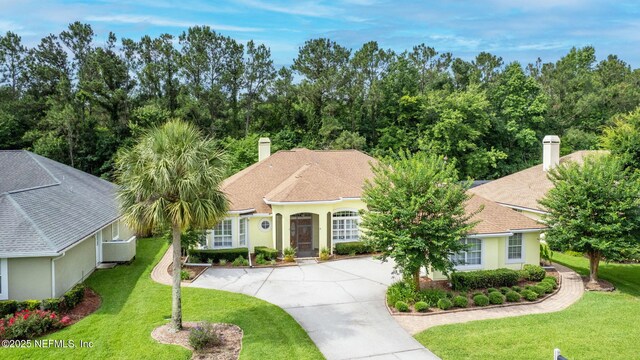 2305 Range Crescent Ct, Fleming Island, FL 32003 - view of front facade with a chimney, a front lawn, stucco siding, and driveway