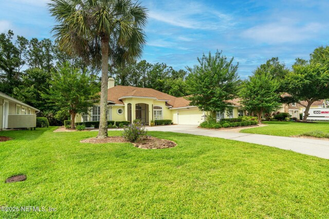 2305 Range Crescent Ct, Fleming Island, FL 32003 - mediterranean / spanish house featuring driveway, a chimney, a garage, a front yard, and stucco siding