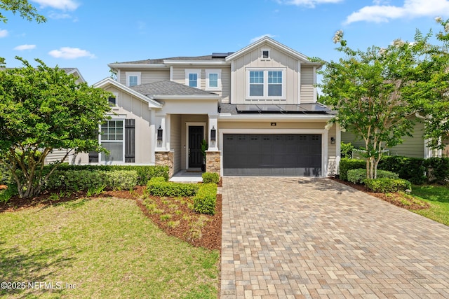 80 Atlas Dr, Saint Augustine, FL 32092 - view of front of home featuring board and batten siding, roof mounted solar panels, decorative driveway, a garage, and a front yard