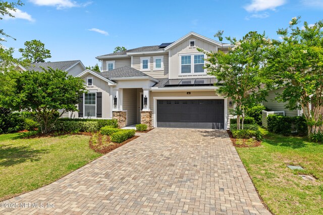 80 Atlas Dr, Saint Augustine, FL 32092 - craftsman house featuring board and batten siding, decorative driveway, solar panels, and a front lawn