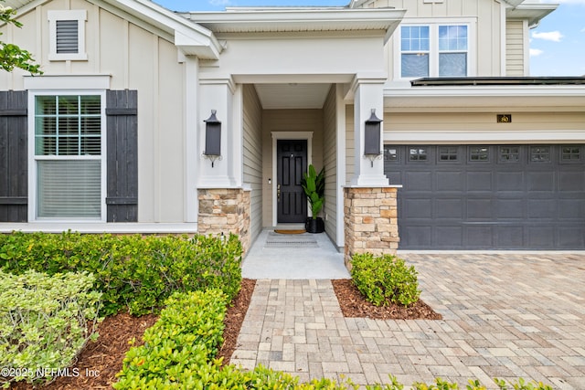 80 Atlas Dr, Saint Augustine, FL 32092 - entrance to property with board and batten siding, stone siding, decorative driveway, and an attached garage