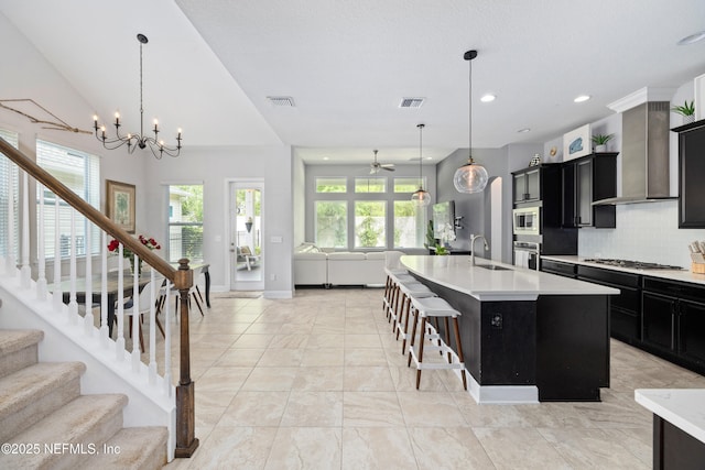 80 Atlas Dr, Saint Augustine, FL 32092 - kitchen featuring open floor plan, stainless steel appliances, dark cabinets, a sink, and wall chimney exhaust hood