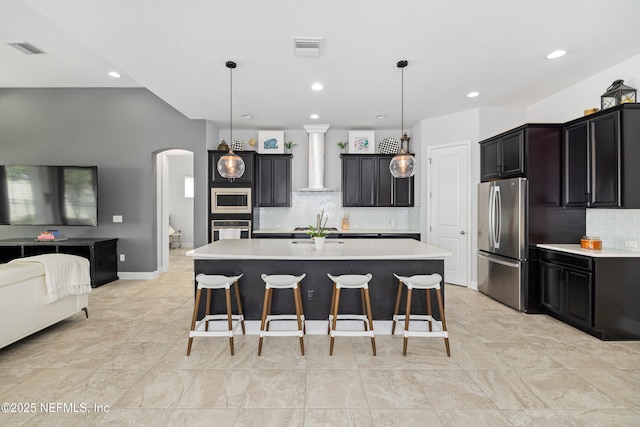 80 Atlas Dr, Saint Augustine, FL 32092 - kitchen featuring stainless steel appliances, wall chimney exhaust hood, arched walkways, light countertops, and recessed lighting