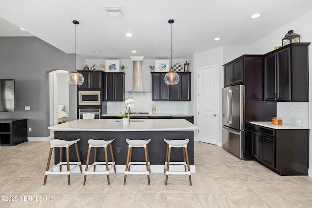 80 Atlas Dr, Saint Augustine, FL 32092 - kitchen featuring appliances with stainless steel finishes, wall chimney exhaust hood, light countertops, tasteful backsplash, and a large island with sink