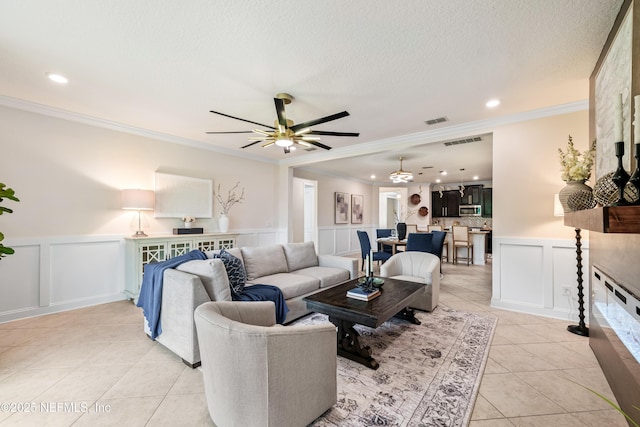 33 Crown Colony Rd, Saint Augustine, FL 32092 - living room with a decorative wall, light tile patterned floors, a ceiling fan, ornamental molding, and a wainscoted wall