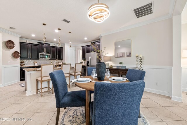 33 Crown Colony Rd, Saint Augustine, FL 32092 - dining space featuring light tile patterned flooring, crown molding, recessed lighting, and a wainscoted wall