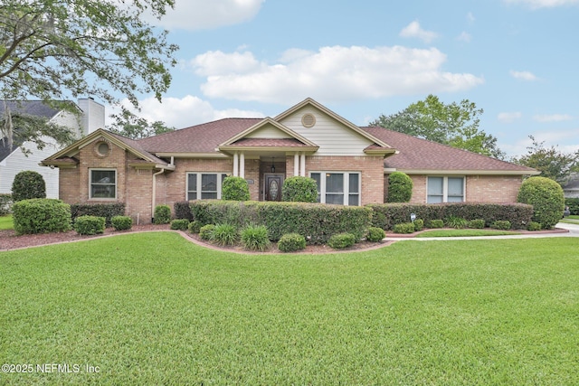 1816 Lakedge Dr, Middleburg, FL 32068 - view of front of property featuring brick siding, a front yard, a chimney, and a shingled roof