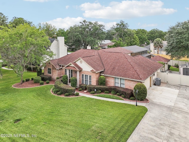 1816 Lakedge Dr, Middleburg, FL 32068 - view of front of house featuring central air condition unit, brick siding, driveway, an attached garage, and a chimney