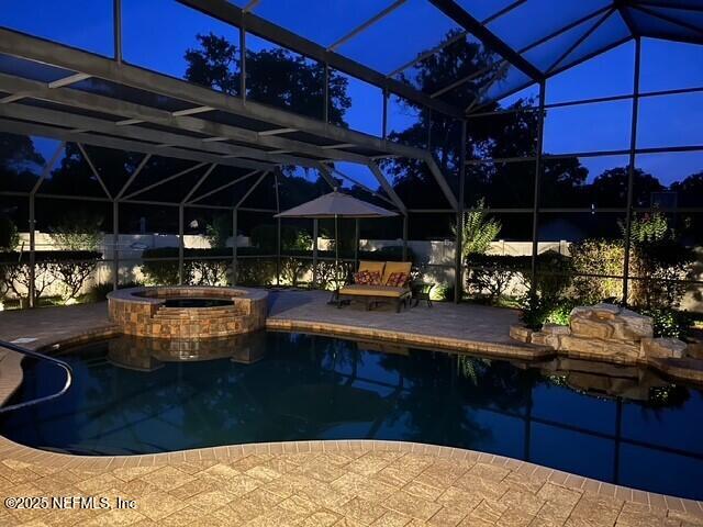 1816 Lakedge Dr, Middleburg, FL 32068 - pool at night with a lanai, a patio, and a pool with connected hot tub