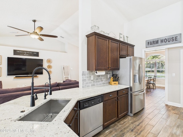 88137 Maybourne Rd, Yulee, FL 32097 - kitchen with stainless steel appliances, open floor plan, a sink, light stone countertops, and ceiling fan