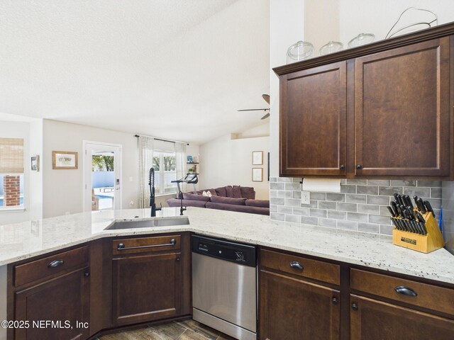 88137 Maybourne Rd, Yulee, FL 32097 - kitchen with stainless steel dishwasher, a sink, dark brown cabinets, tasteful backsplash, and light stone counters
