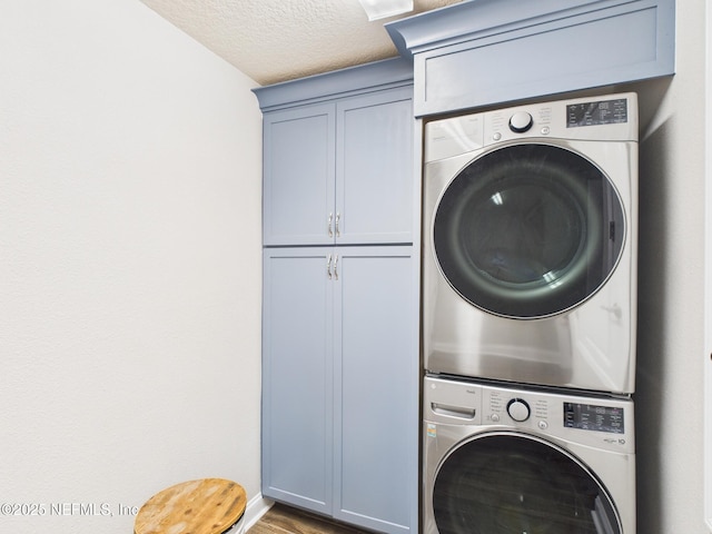 88137 Maybourne Rd, Yulee, FL 32097 - washroom with stacked washer / drying machine, cabinet space, wood finished floors, a textured ceiling, and baseboards