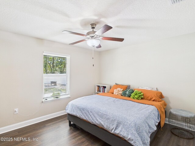 88137 Maybourne Rd, Yulee, FL 32097 - bedroom with dark wood finished floors, baseboards, a textured ceiling, and a ceiling fan