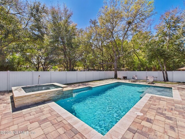88137 Maybourne Rd, Yulee, FL 32097 - view of pool with a patio area, a fenced backyard, a pool with connected hot tub, and view of wooded area
