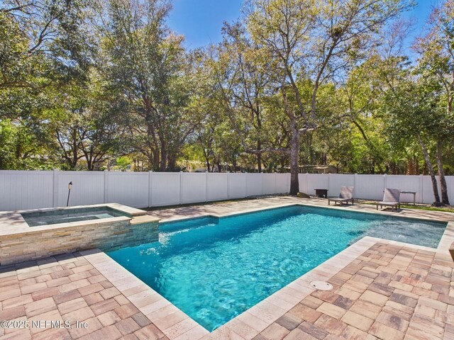 88137 Maybourne Rd, Yulee, FL 32097 - view of swimming pool featuring a patio, a fenced backyard, a pool with connected hot tub, and view of wooded area