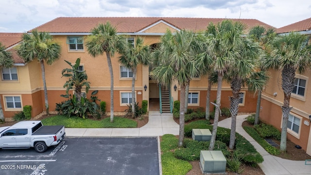 104 Laguna Villas Blvd Unit F33, Jacksonville Beach, FL 32250 - view of building exterior featuring uncovered parking and stairs