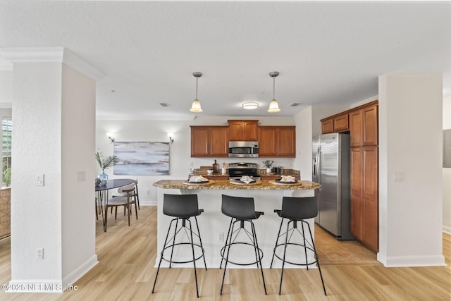 104 Laguna Villas Blvd Unit F33, Jacksonville Beach, FL 32250 - kitchen with stainless steel appliances, light wood-type flooring, baseboards, a breakfast bar, and light stone countertops