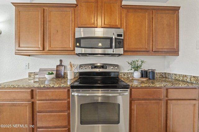 104 Laguna Villas Blvd Unit F33, Jacksonville Beach, FL 32250 - kitchen featuring appliances with stainless steel finishes, stone counters, and brown cabinets