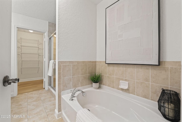 104 Laguna Villas Blvd Unit F33, Jacksonville Beach, FL 32250 - full bath with a garden tub, a shower stall, a textured wall, and tile patterned flooring