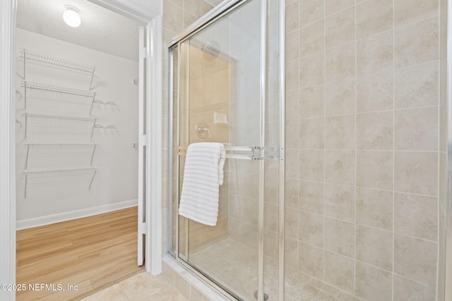104 Laguna Villas Blvd Unit F33, Jacksonville Beach, FL 32250 - full bath featuring a shower stall, a spacious closet, baseboards, and wood finished floors