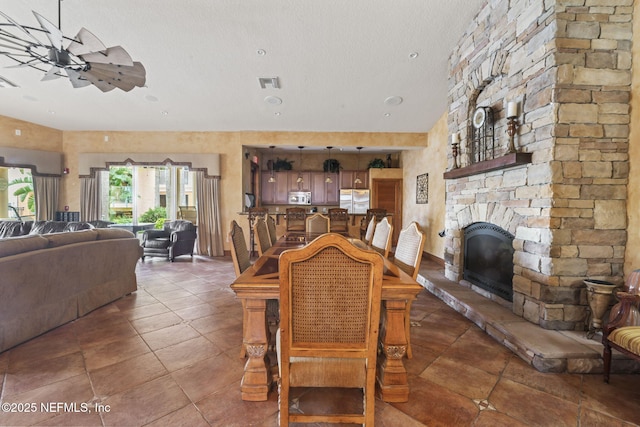 104 Laguna Villas Blvd Unit F33, Jacksonville Beach, FL 32250 - tiled dining room with a ceiling fan, a textured ceiling, and a stone fireplace