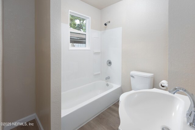 736 W St, Jacksonville, FL 32204 - full bathroom with bathtub / shower combination, wood finished floors, toilet, and a textured wall