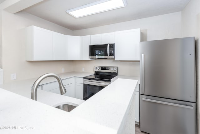 736 W St, Jacksonville, FL 32204 - kitchen with appliances with stainless steel finishes, a sink, light countertops, and white cabinets