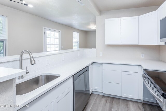 736 W St, Jacksonville, FL 32204 - kitchen featuring appliances with stainless steel finishes, a sink, white cabinets, light stone counters, and light wood finished floors